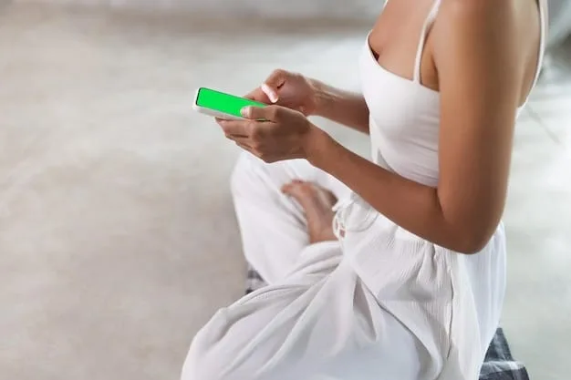 A close-up shot of a person's hand using a mindfulness meditation app on their smartphone, showcasing how technology can be used to enhance and support meditation practices.