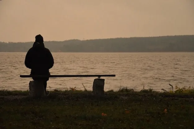 A solitary figure sitting alone on a park bench, head in hands, conveying a sense of deep loneliness and isolation. The background is blurred.
