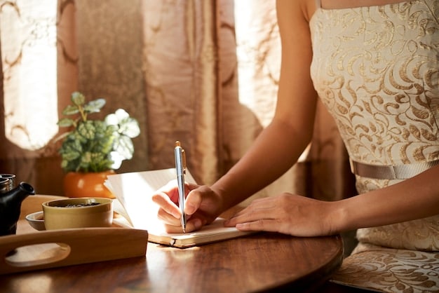 A close-up shot of hands writing in a journal with the word 