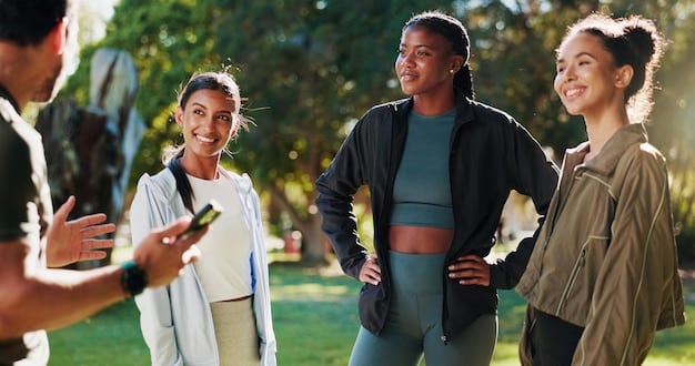 A group of diverse people participating in a community fitness event, wearing fitness trackers and smiling.