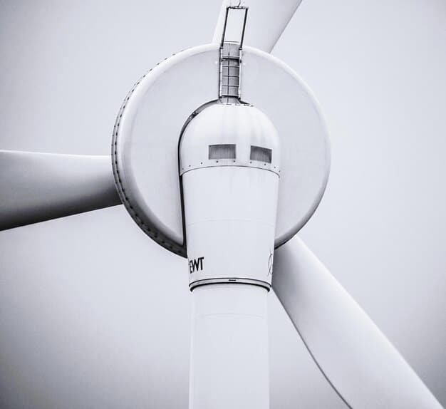 Close up shot of a wind turbine blade being manufactured in a modern factory. The focus is on the precision and technology involved in creating these renewable energy components.