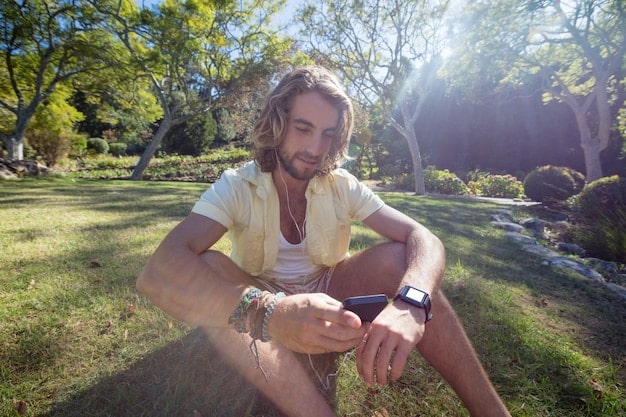 A person using a guided meditation app on their smartwatch, with their hand resting peacefully in their lap. The background is a serene natural setting.