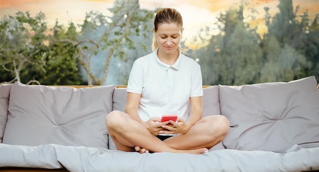 A person sitting on a couch using a smartphone app designed for meditation. The app interface is visible, showing options for guided meditations and relaxation techniques. The person appears relaxed and focused, highlighting the convenience of using technology for mental wellness.