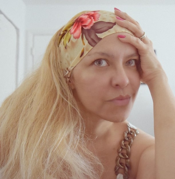 A close-up shot of a person wearing a Muse headband while meditating. The image shows the technology seamlessly integrating into a moment of personal relaxation and focus. The angle emphasizes the sleek design of the device and its unobtrusive nature.