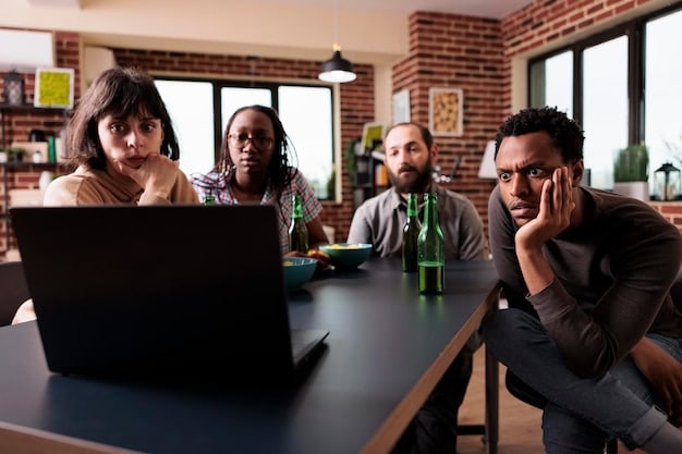A diverse group of US professionals in an open office space, some looking stressed and overwhelmed, while others appear relaxed and engaged in their work, illustrating the mixed experiences related to workplace burnout.