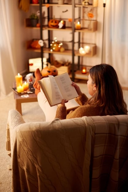 A person sitting comfortably near a light therapy box, reading a book, in a cozy room setting.