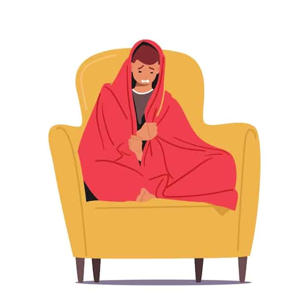 A person sitting on a couch, wrapped in a blanket, looking sad and forlorn. The room is dimly lit, and there is a calendar in the background showing the month of December. This image is a depiction of sadness and isolation.